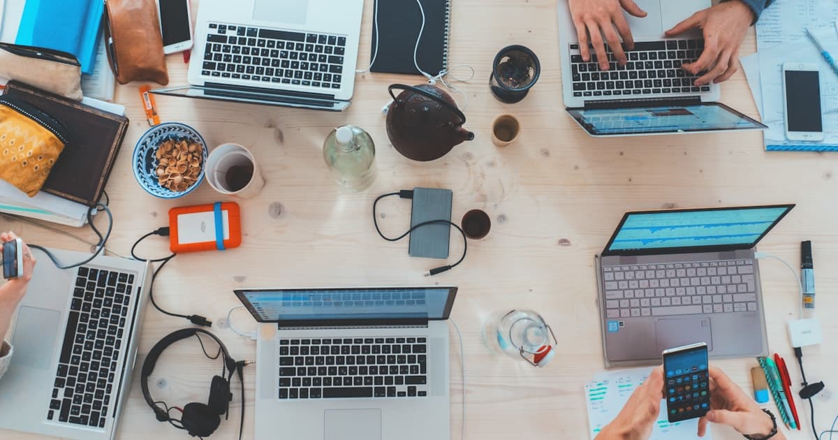 Team organising documents and notes around a laptop