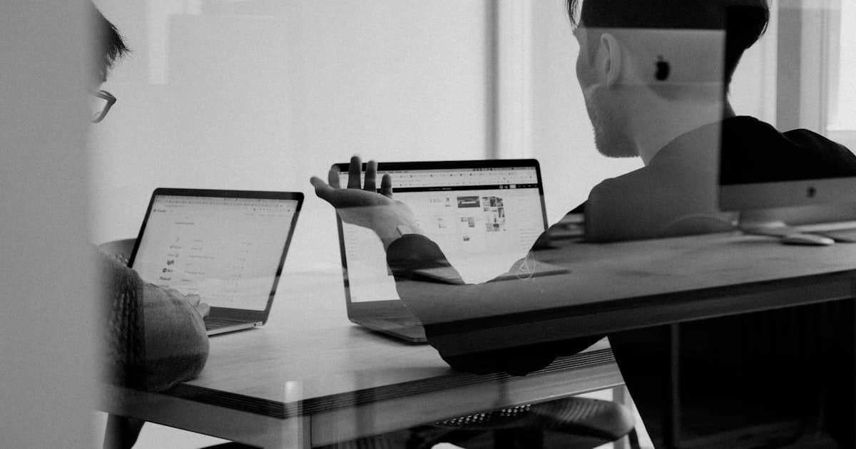 Person comparing software options on a laptop in a small office