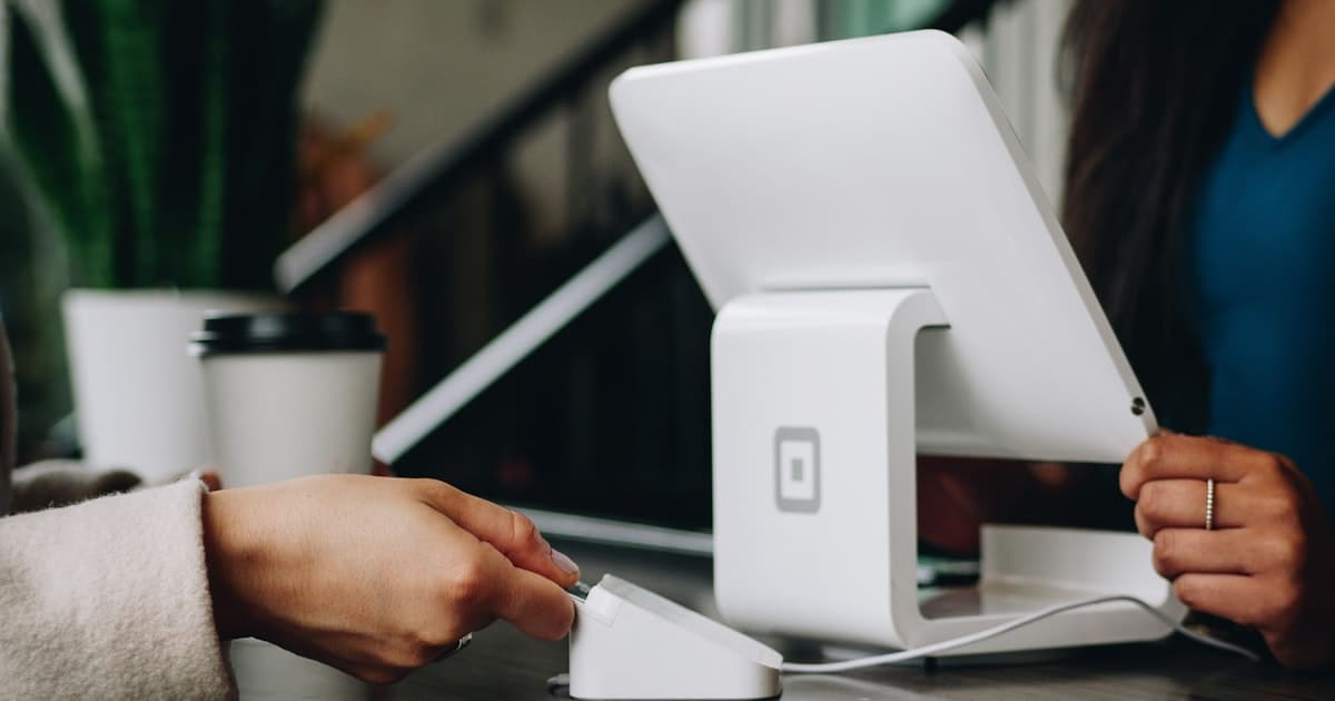Small business owner reviewing options at a desk with a phone and laptop